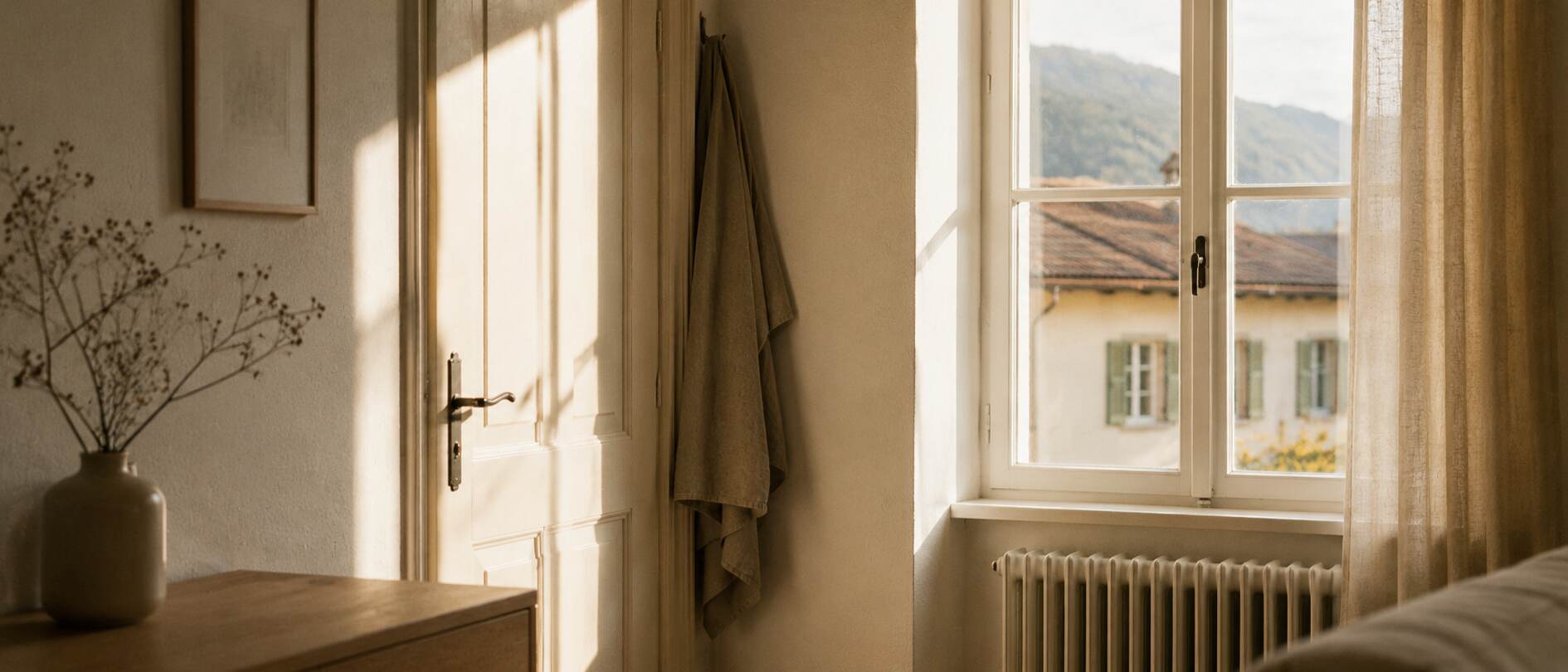 Sonniges Zimmer mit Blick auf ein Wohnhaus und Berge